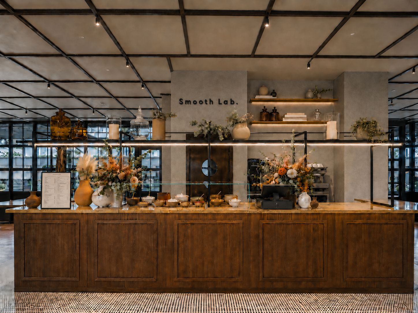 La barra de Smooth Lab, de nogal y piedra, con el letrero de la marca